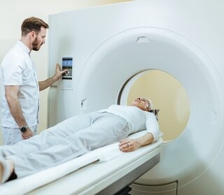 Doctor performing CCTA on CT scan machine for heart check-up.